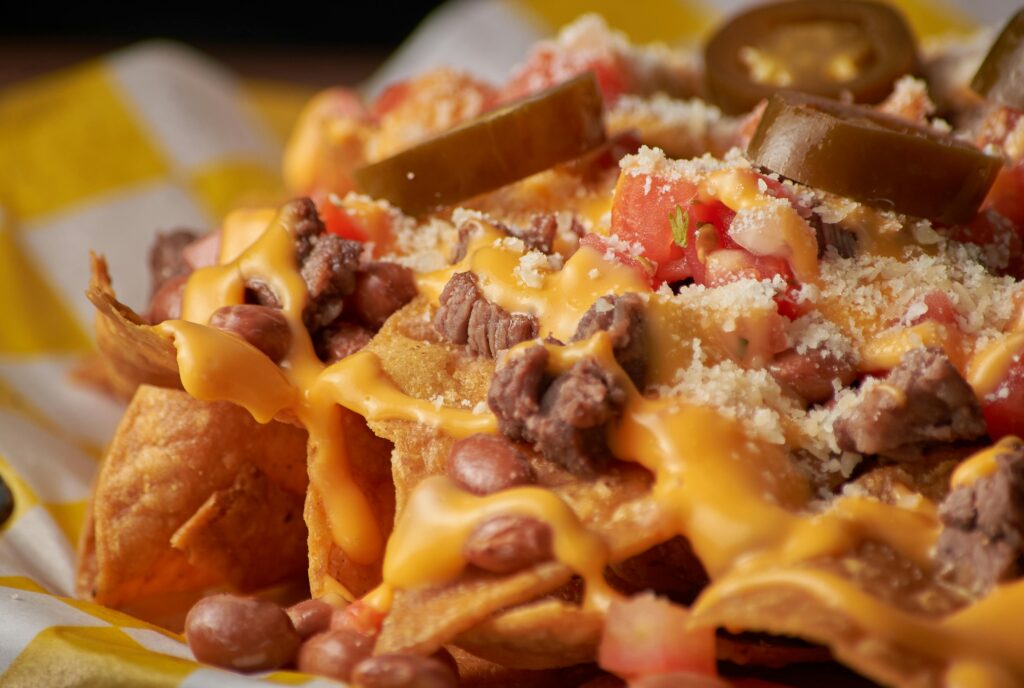 pexels-photo-12557551-12557551 Delicious close-up of nachos topped with cheese, jalapeños, and beans, perfect for food lovers.