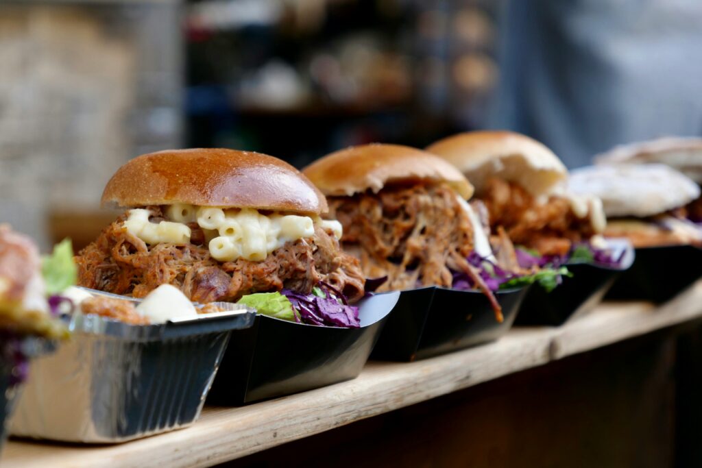 pexels-photo-3753488-3753488 Tasty pulled pork sandwiches topped with creamy macaroni in a London market setting.